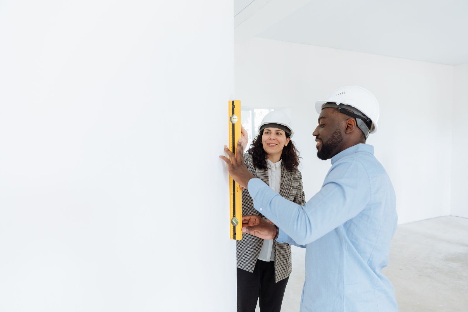 Engineers checking a wall with a level on site