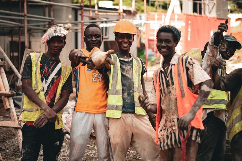 Smiling construction workers in safety vests and helmets