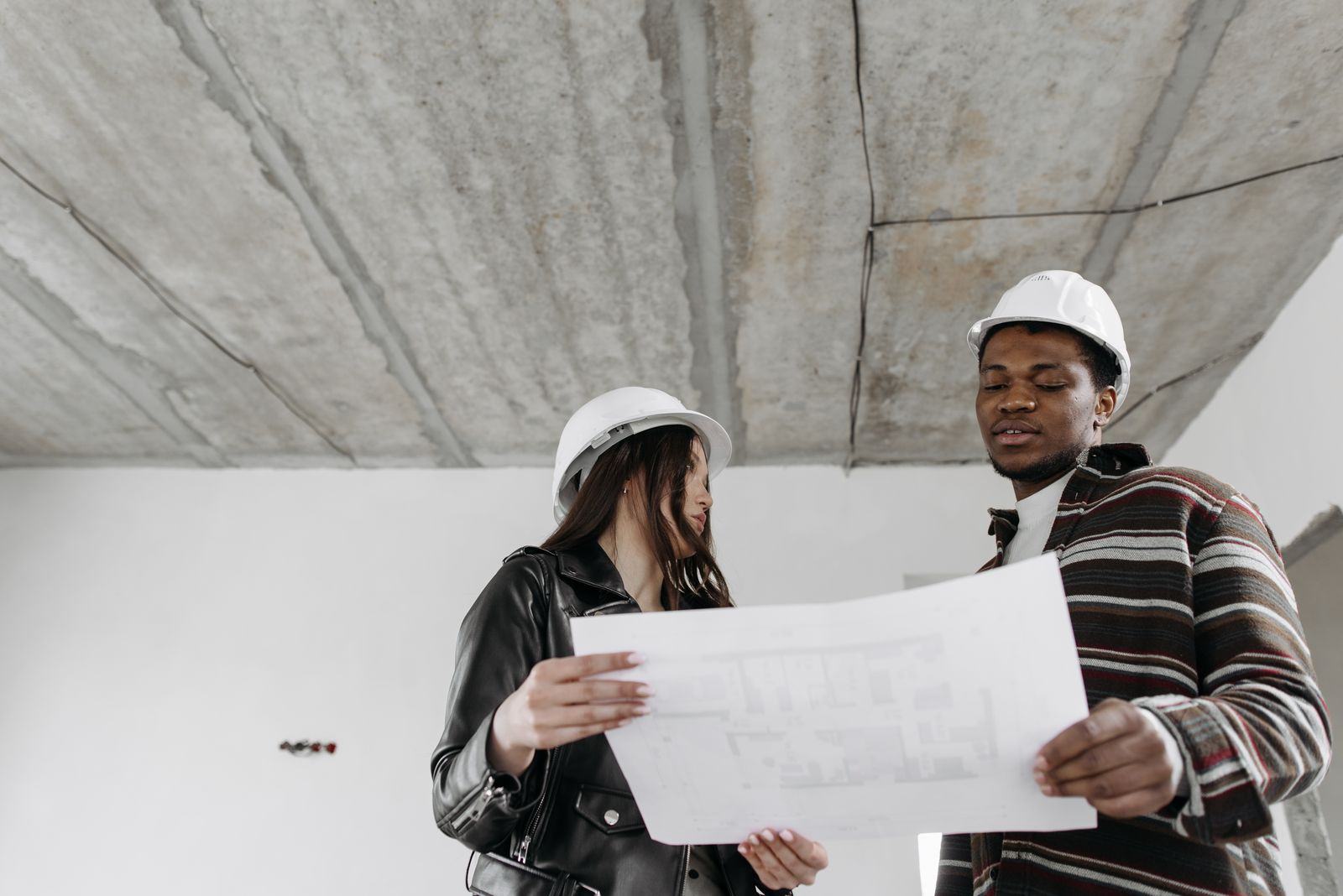 Engineers reviewing building plans together on site