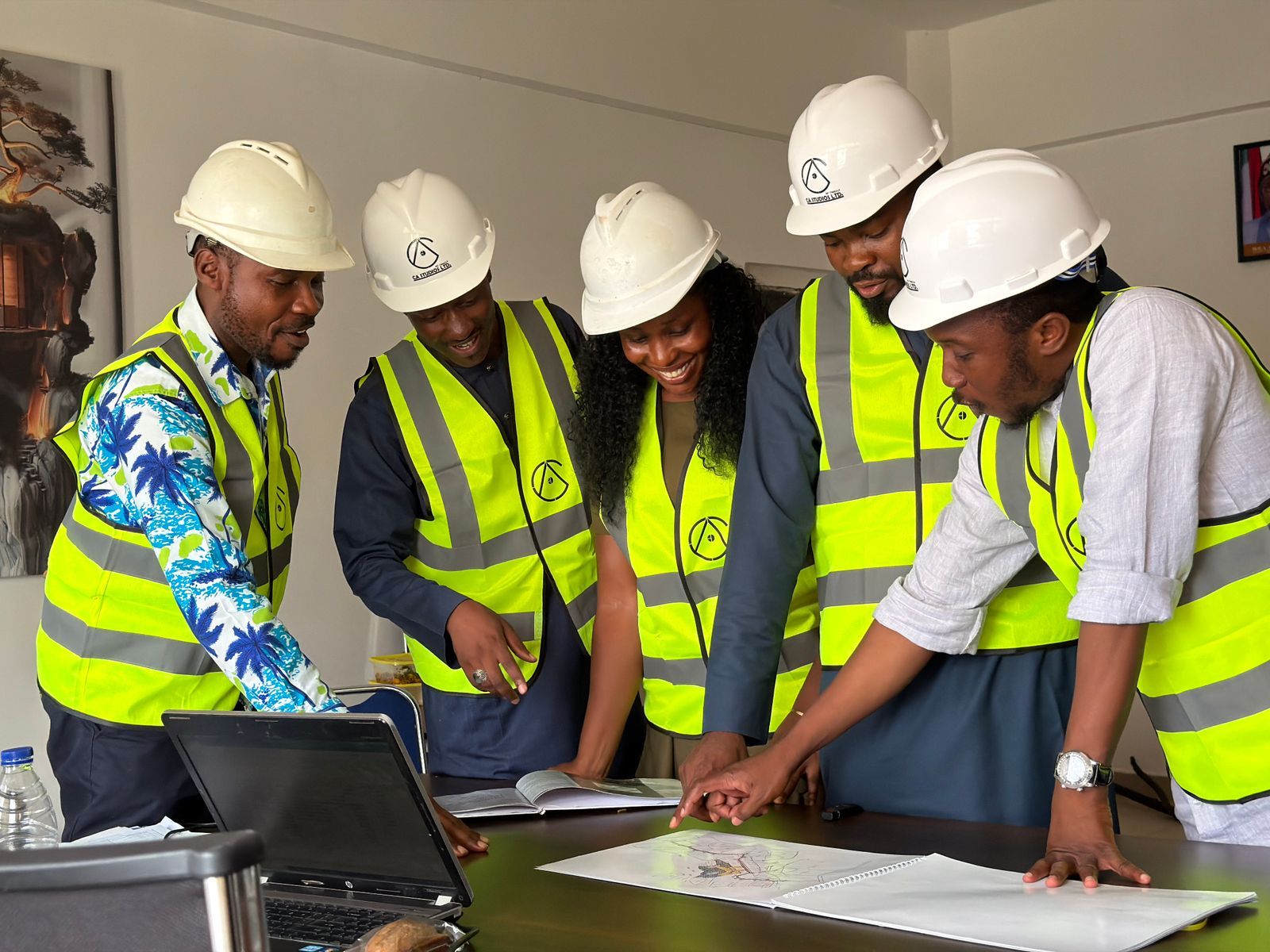 Engineers in hard hats and safety vests reviewing drawings