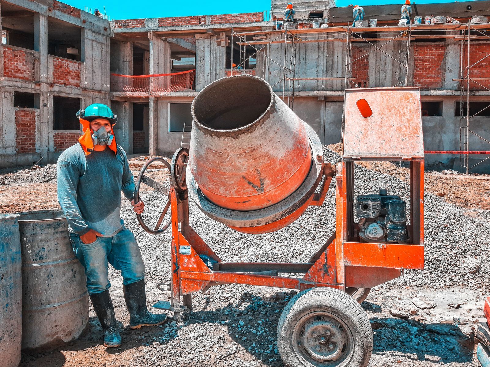 A construction worker operating a concrete mixer at an active building site