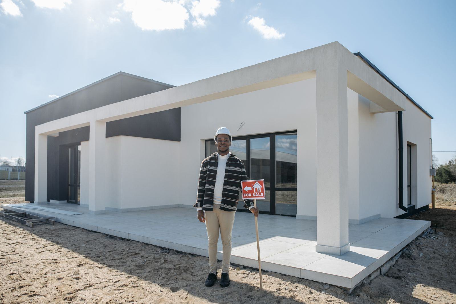 Homeowner standing in front of a newly built modern house