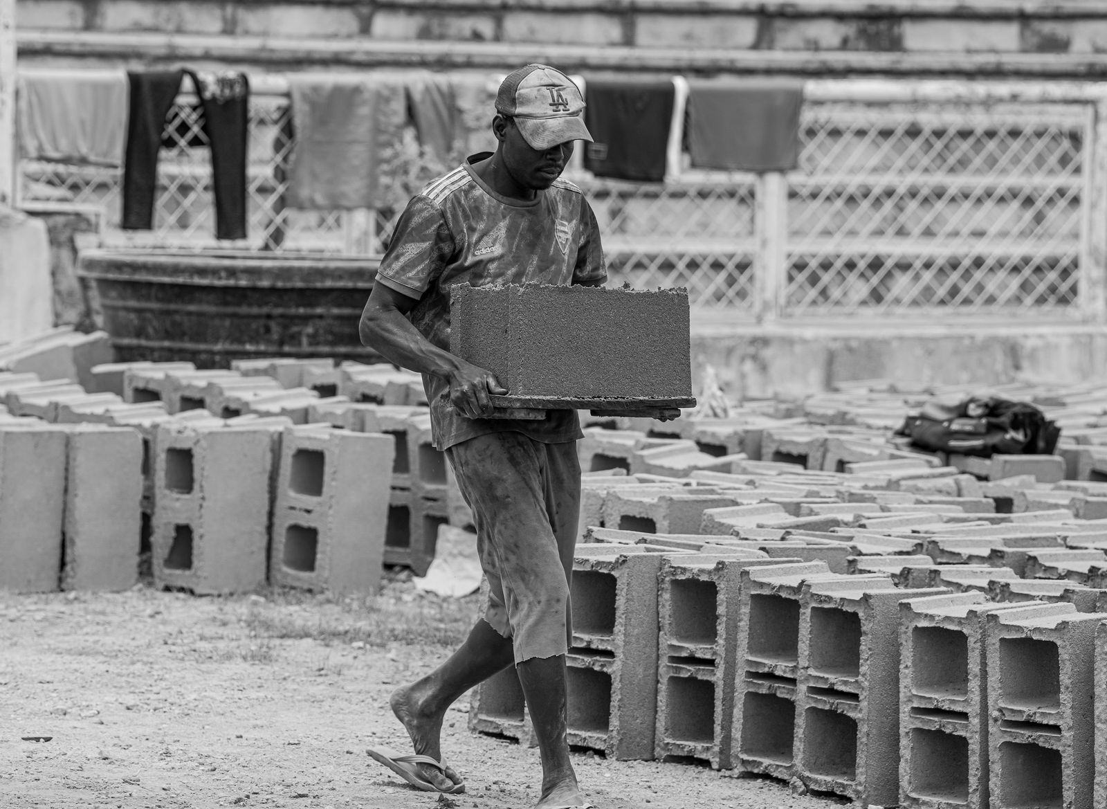 Construction worker carrying concrete blocks on a building site