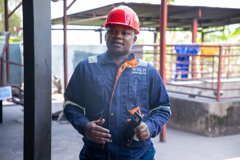 Site manager in a red hard hat standing on a construction site