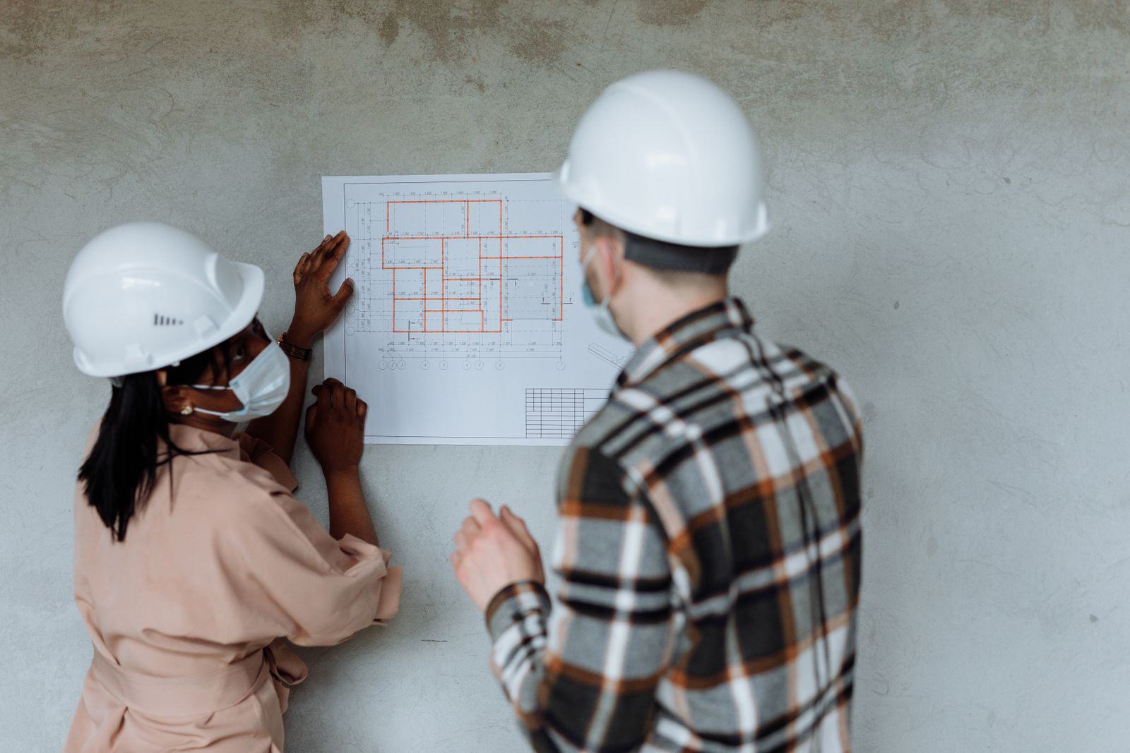 Engineers discussing plans in front of a whiteboard