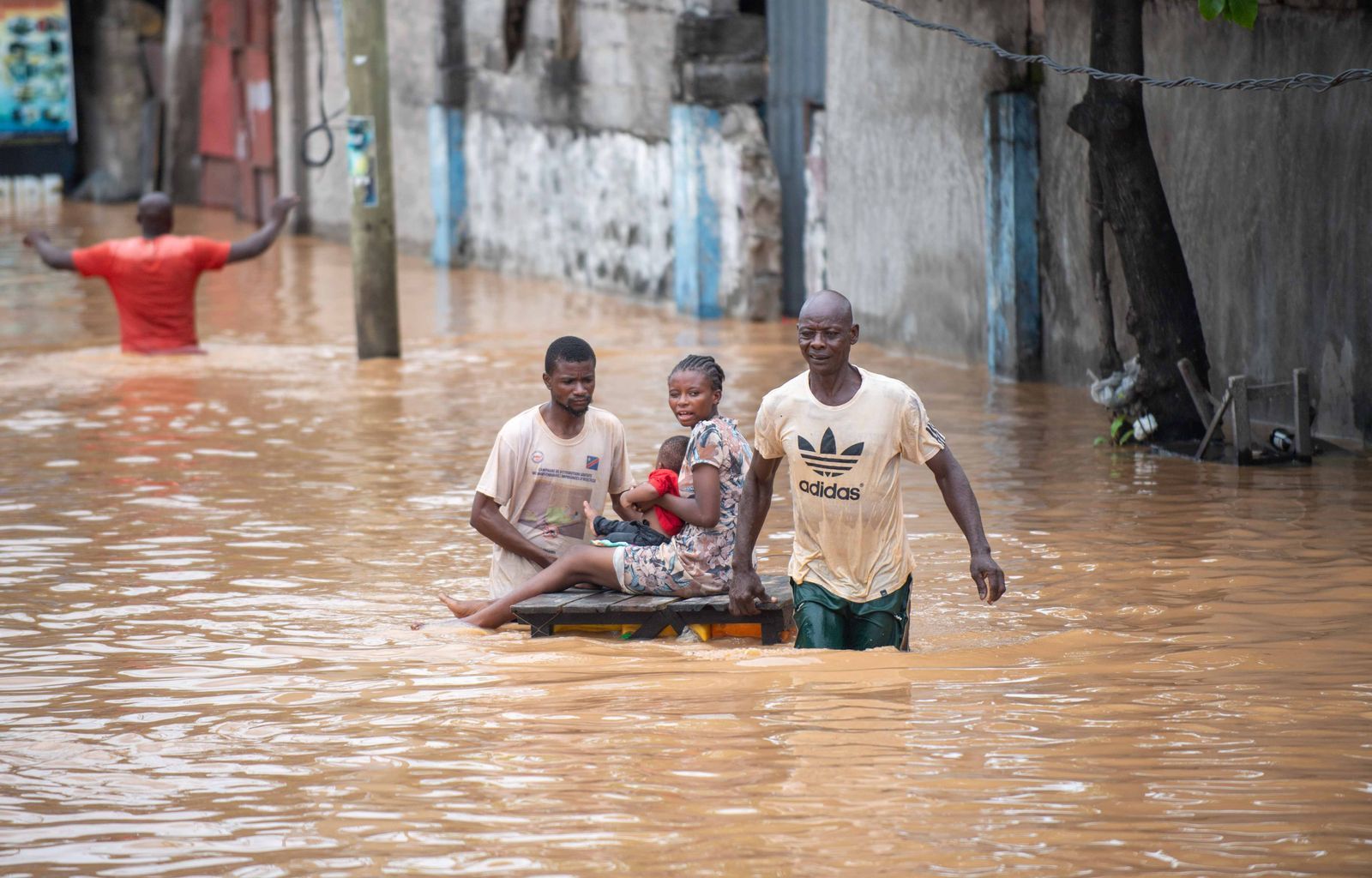 People wading through a flooded street after heavy rain