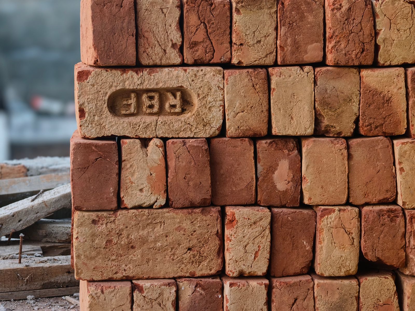 A pile of red clay bricks at a construction site