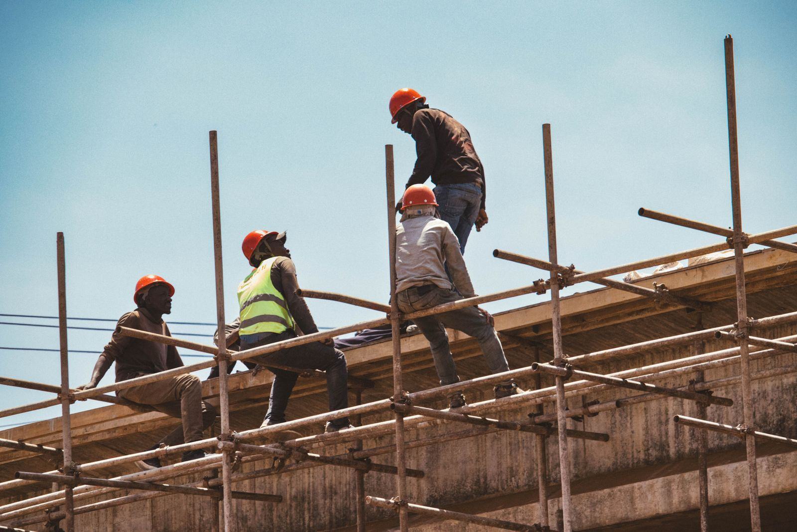 Construction workers on a building structure under a clear sky
