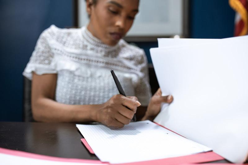Woman signing financial documents at a desk