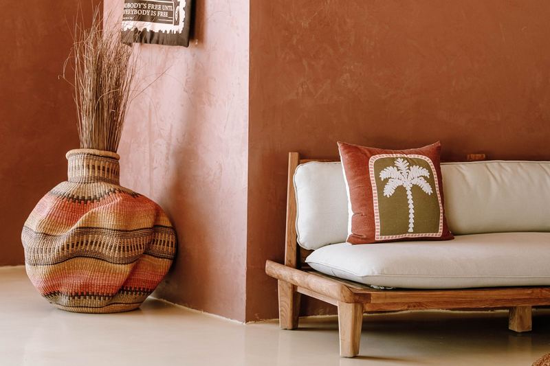 Bohemian living room with a wicker vase and palm-themed cushion in Jambiani, Tanzania