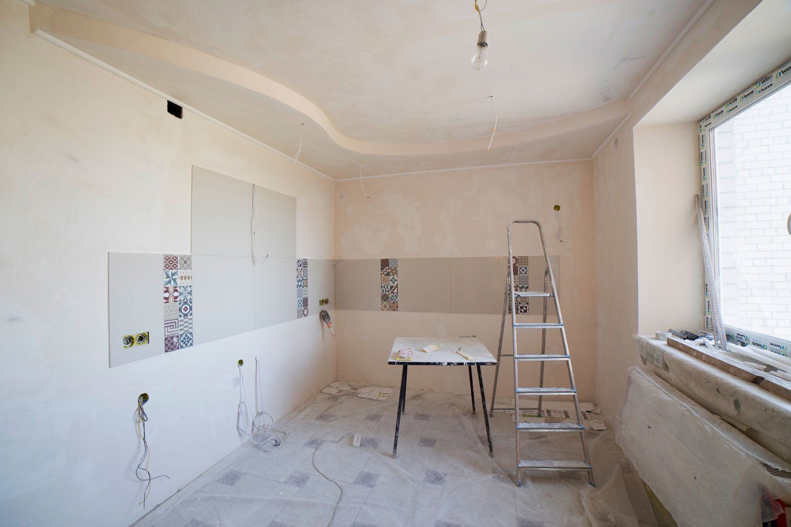 Interior space being renovated with ladder and stripped walls