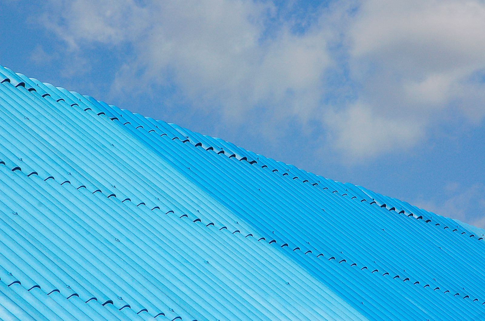 Blue pre-painted roofing sheets against the sky