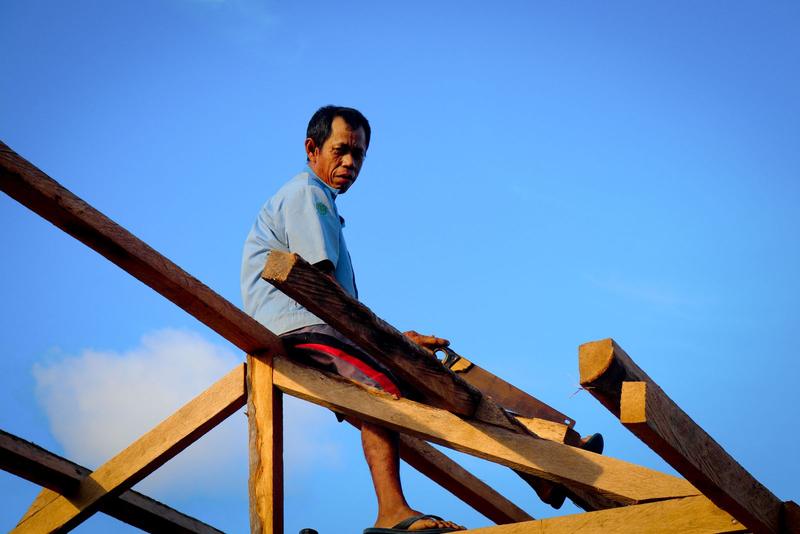 Worker building a timber roof structure