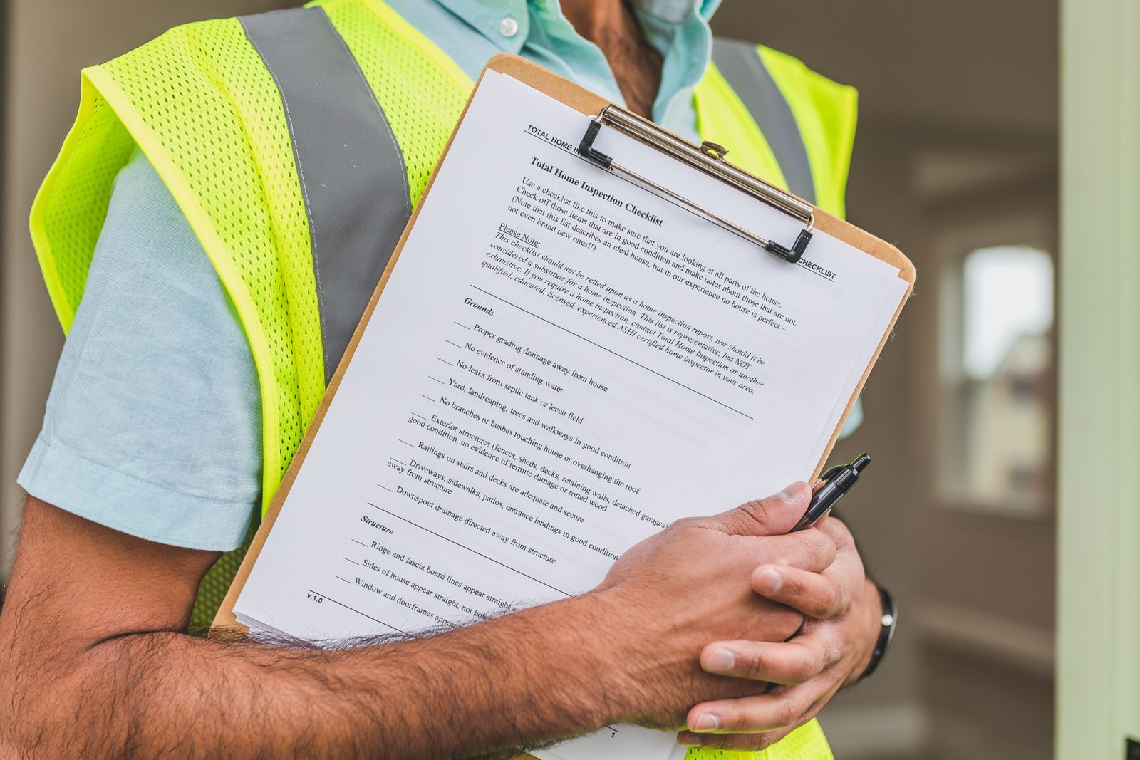 Close-up of home inspector holding a checklist on a clipboard with a pen