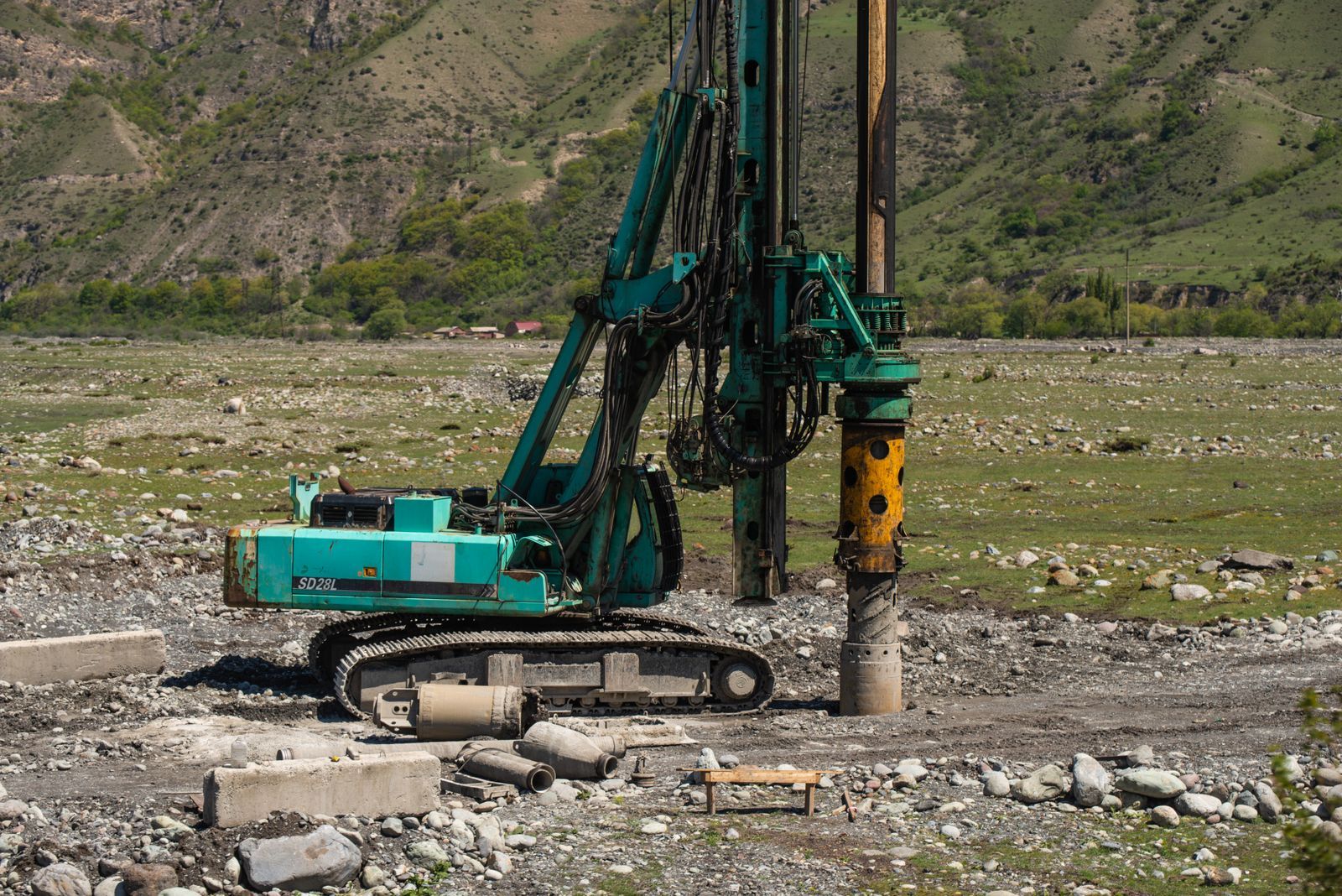 A heavy drilling machine in use on a rugged outdoor construction site
