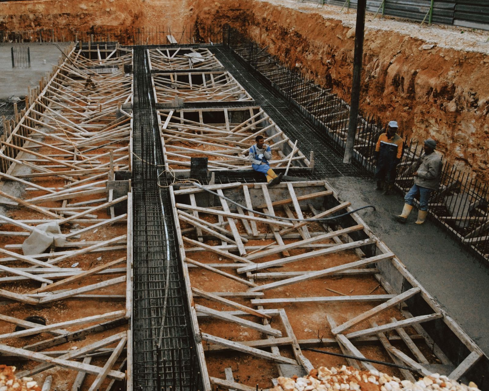 Construction workers at a site with wooden framework in progress