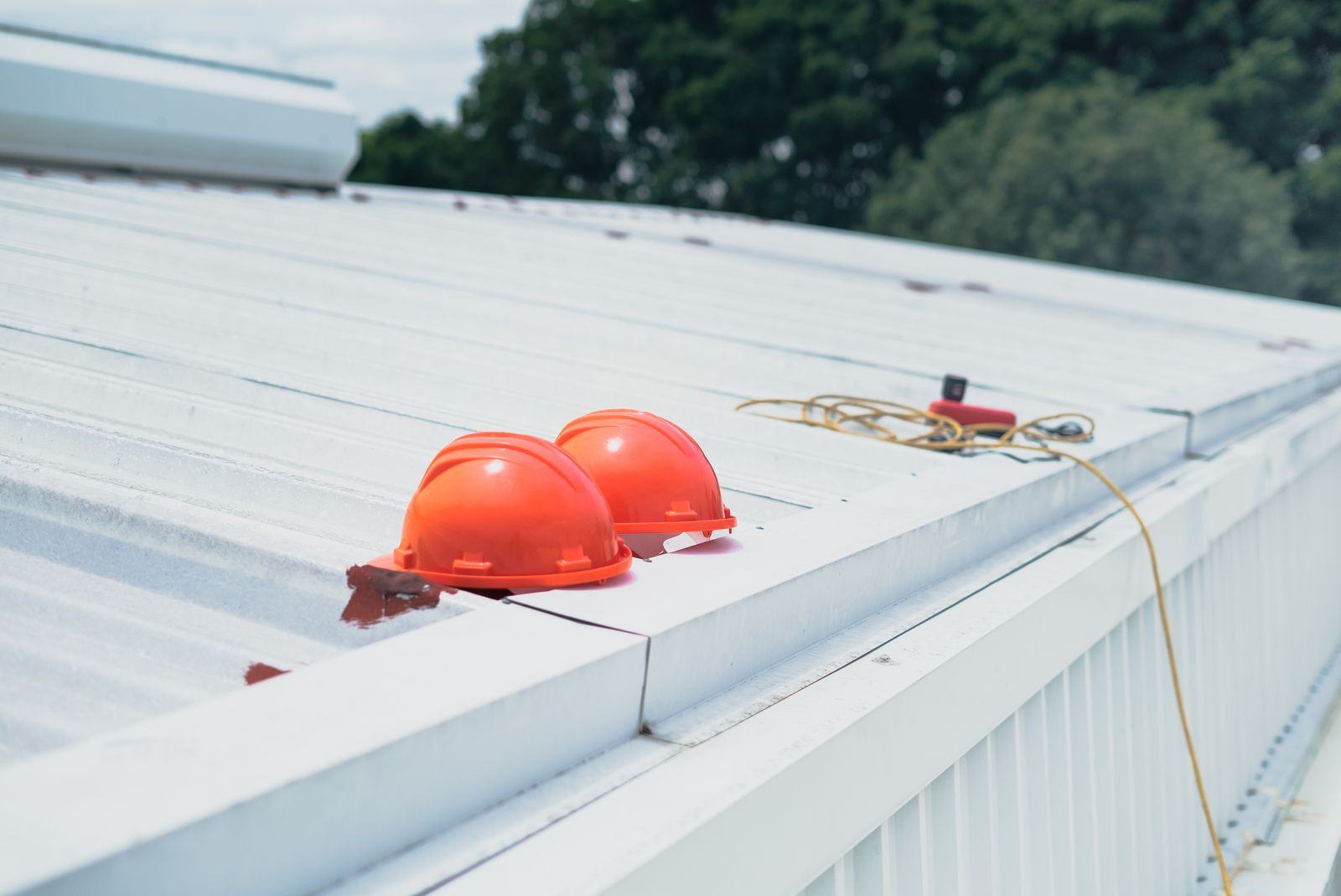White roof membrane on a building with hard hats on top