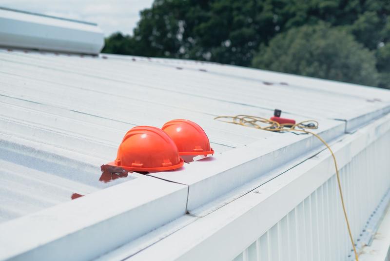 White roof membrane on a building with hard hats on top