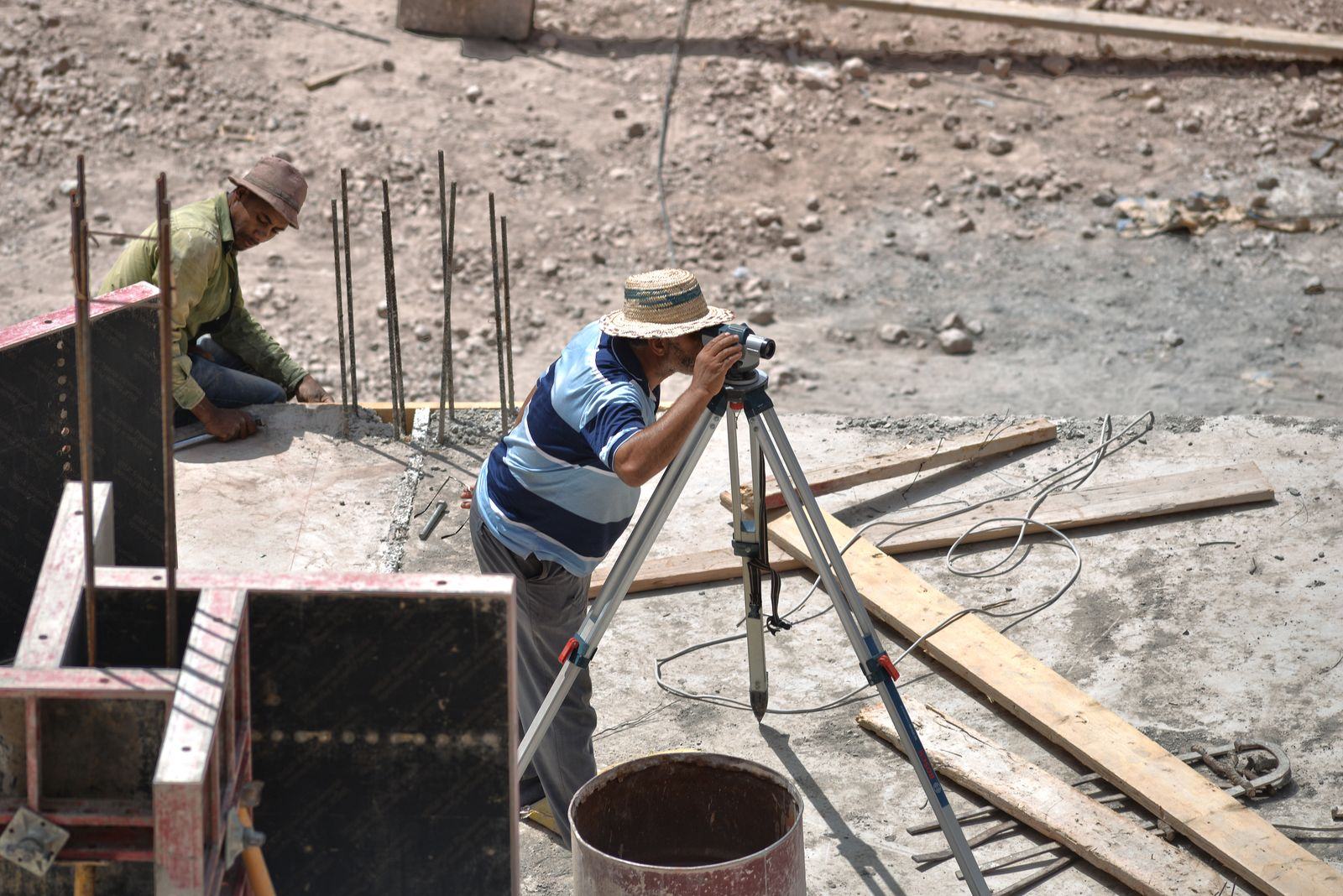 Surveyor setting up a level on a construction site