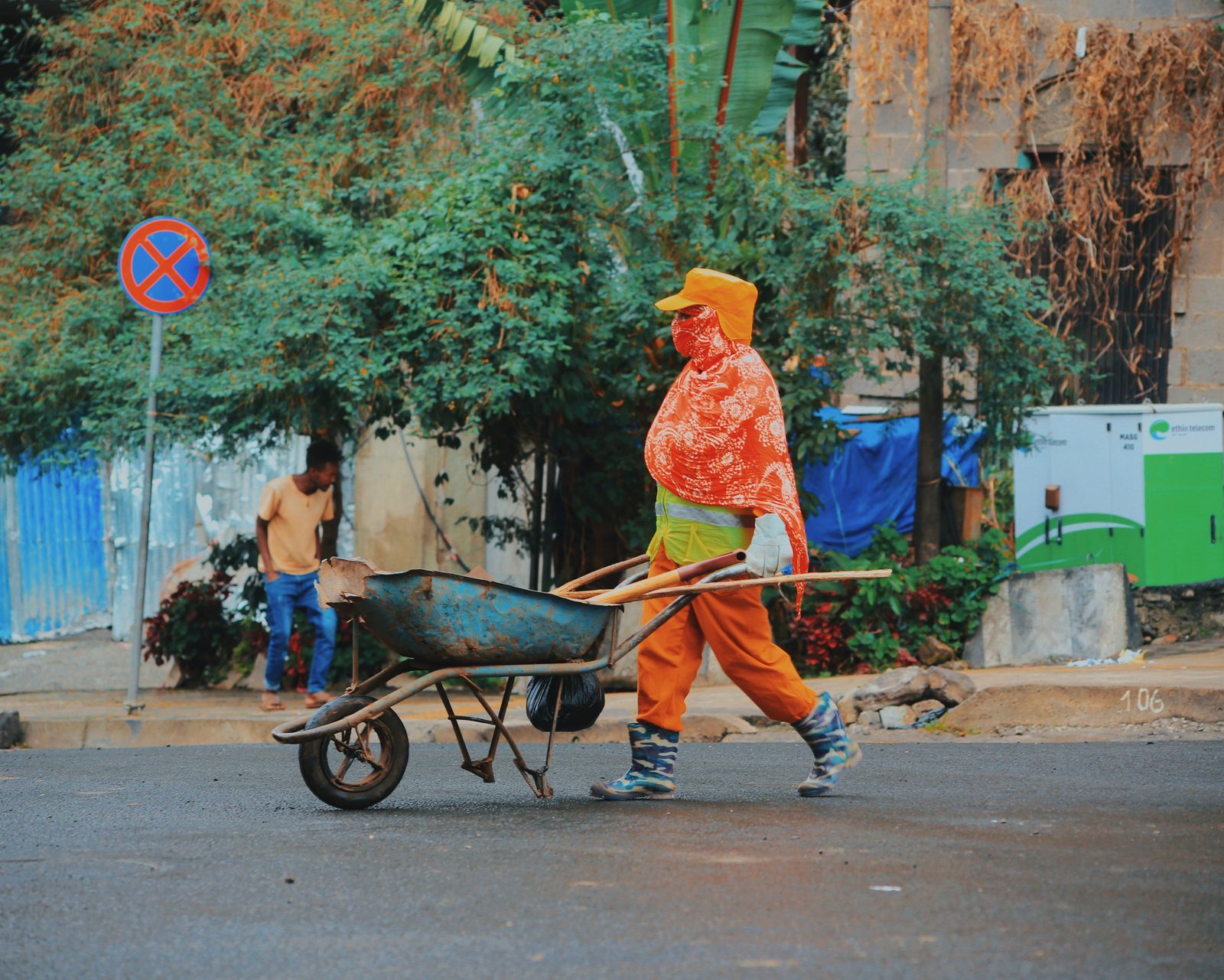 A construction worker pushes a wheelbarrow in an urban street in Addis Ababa, Ethiopia